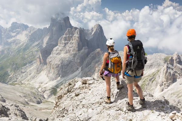 a view of two hikers climbing on the Rosengarten mountain along the via ferrata 