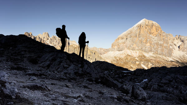 a view of two hikers standing in shadow, looking to the Tofana peak, Belluno province, Veneto, Italy, Europe,  