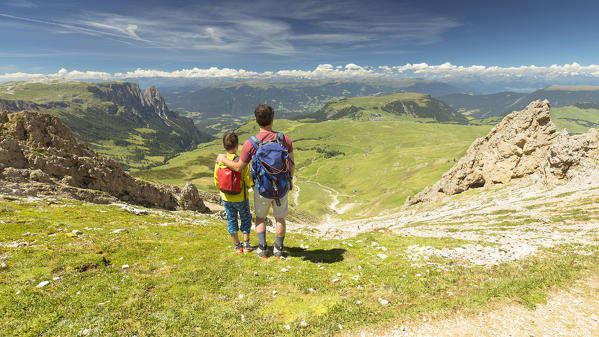 a father with his son are looking at the landscape from the top of the Seiser Alm, (Alpe di Siusi), Bolzano province, South Tyrol, Trentino Alto Adige, Italy