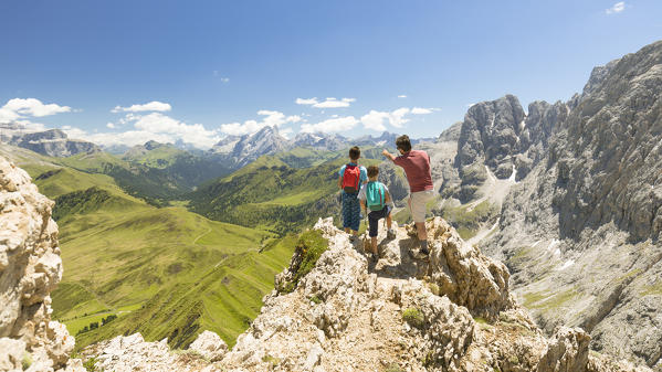 a family is looking at the beautiful landscape from the top of the Seiser Alm, (Alpe di Siusi), Bolzano province, South Tyrol, Trentino Alto Adige, Italy