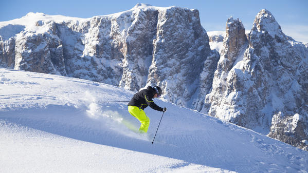  a skier is skiing in the fresh snow with the Schlern in the background, Bolzano province, South Tyrol, Trentino Alto Adige, Italy