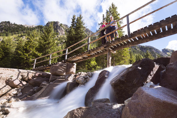 a family on a wood bridge along a footpath in Villnössertal, Bolzano province, South Tyrol, Trentino Alto Adige, Italy