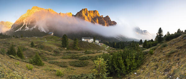 a beautiful sunset in Val Gardena (Gröden) with a hut and the Dolomites radiated by the last ray of the sun, Bolzano province, South Tyrol, Trentino Alto Adige, Italy