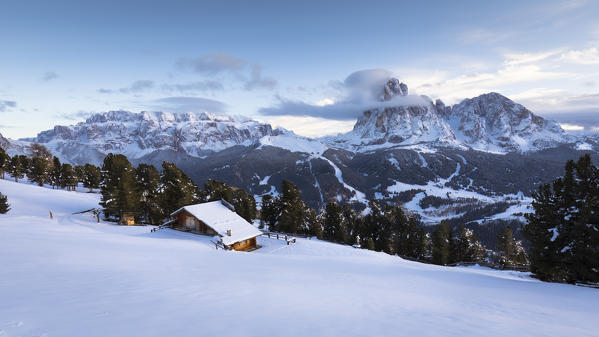 a winter view of the Val Gardena with Sella Group and Langkofel Group in the background and a small hut in the foreground, Bolzano province, South Tyrol, Trentino Alto Adige, Italy
