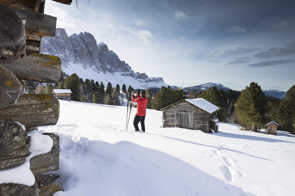 a view of several huts with the Geisler Group in the background from the Gampen Alm in Villnössertal, Bolzano province, South Tyrol, Trentino Alto Adige, Italy