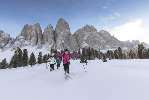 a group of hikers is running down with snowshoes in Villnössertal with the Geisler in the background, Bolzano province, South Tyrol, Trentino Alto Adige, Italy