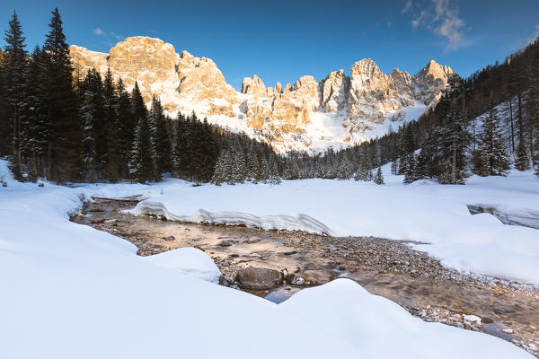 a winter landscape of the Pala Group with a flowing creek in the foreground, Trento province, Trentino Alto Adige, Italy