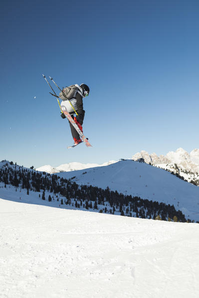 a view of a freestyler flying with his skis after a jump in Val Gardena, Bolzano province, South Tyrol, Trentino Alto Adige, Italy