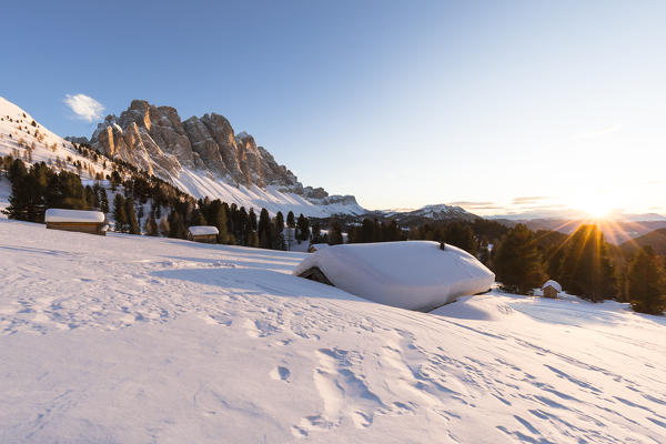 a beautiful sunset on the Geisler in Villnössertal with a group of mountain huts in the foreground, Bolzano province, South Tyrol, Trentino Alto Adige, Italy,