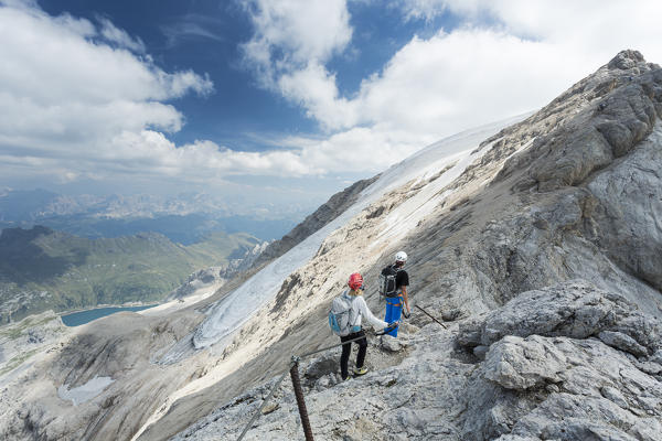 two hikers along a via ferrata on the Marmolada with the glacier in the background, Trento province, Trentino Alto Adige, Italy, 