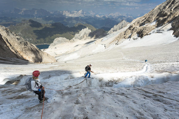 two hikers are walking on the glacier on the Marmolada, Trento province, Trentino Alto Adige, Italy, 