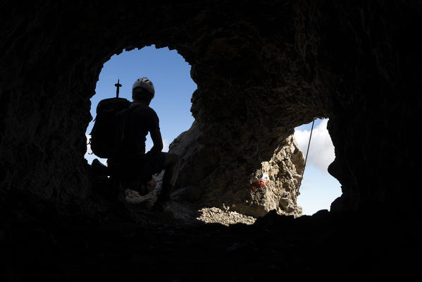 a climber into a war tunnel along the via ferrata Bepi Zac, on the battlefront of the World War One, Trento Province, Trentino Alto Adige, Italy