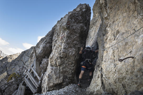 a climber is passing through the rocks along the via ferrata Bepi Zac on the battlefront of the World War One, Trento Province, Trentino Alto Adige, Italy