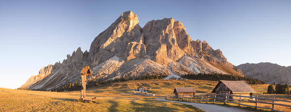 Sunset on the Peitlerkofel with a Wood crucifix and little huts, Bolzano province, South Tyrol, Trentino Alto Adige, Italy