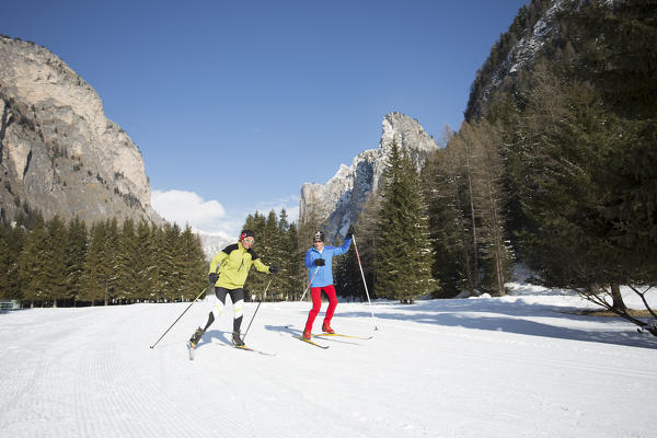 two skiers are on the cross-country slopes in Val Gardena, Bolzano province, South Tyrol, Trentino Alto Adige, Italy
