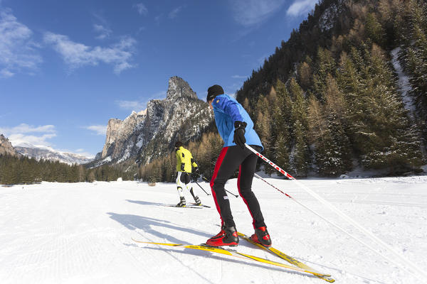 two skiers are on the cross-country slopes in Val Gardena, Bolzano province, South Tyrol, Trentino Alto Adige, Italy