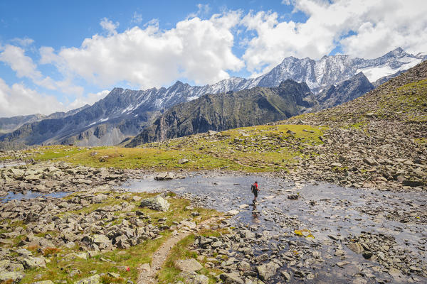A man hiking through Rinnenkarbach with the Sommerwand and the Stubai Alps in the background, Neustift, Innsbruck Land, Tyrol, Austria, Europe