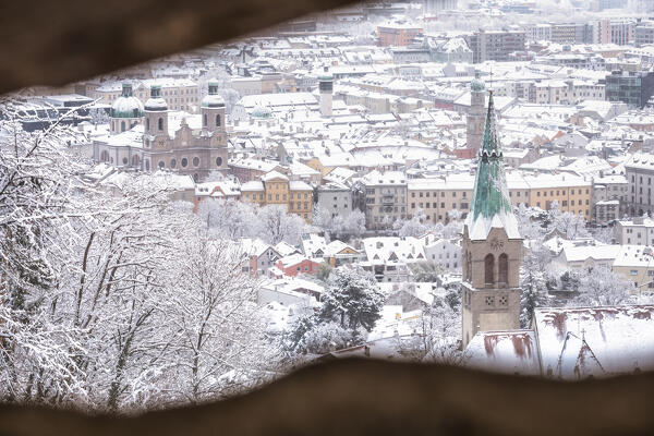 The inner city of Innsbruck on a snowy morning with the bell tower of the Sankt Nikolaus Church in the foreground, innsbruck, Tyrol, Austria, Europe