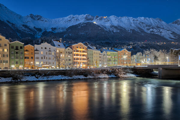 The classic view of the snow covered Mariahilf buildings with the Nordkette mountains in the background on a cold freezing evening, Innsbruck, Tyrol, Austria, Europe