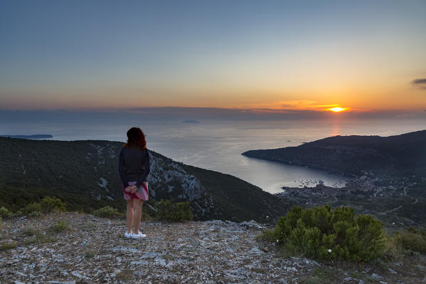A girl looks the landscape and the village of Komiza from Hum mount at sunset (Komiza, Vis Island, Split-Dalmatia county, Dalmatia region, Croatia, Europe) (MR)
