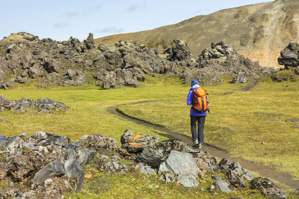Graenagil footpath: a trekker is walking through the Laugahraun lava field in Landmannalaugar (Fjallabak Nature Reserve, Highlands, Southern Region, Iceland, Europe) (MR)