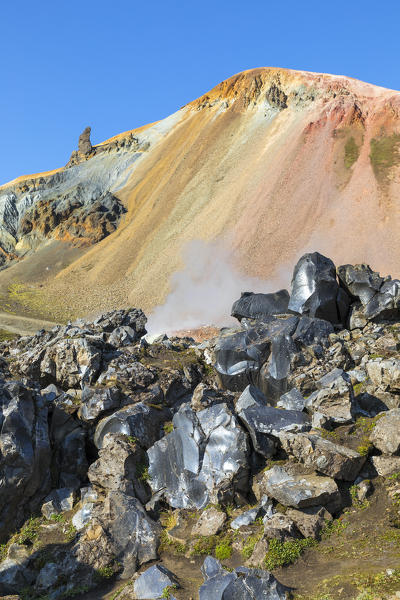 Rocks of the Laugahraun lava field and the Brennisteinsalda mountain on background from the Graenagil footpath in Landmannalaugar (Fjallabak Nature Reserve, Highlands, Southern Region, Iceland, Europe)
