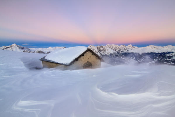 Valtellina, Central Alps, Sondrio district, Lombardy, Italy. Pristine snow on a windy sunset.