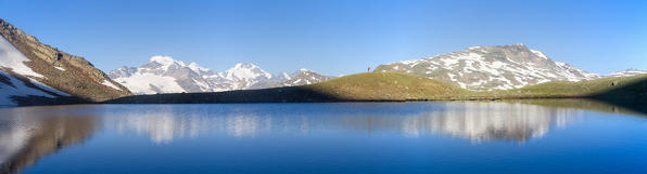 Panoramic mirror view of Vago lake in Livigno, Alps, Europe, Italy, Lombardy, Sondrio