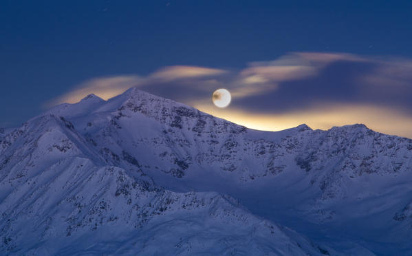 Europe, Italy, Lombardy, Sondrio. Moony sunrise from mount Cevedale in italian Alps of Valfurva