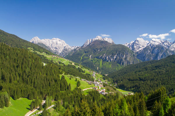 The village of Santo Stefano di Cadore in the Dolomites in the green summer landscape and the peaks still white