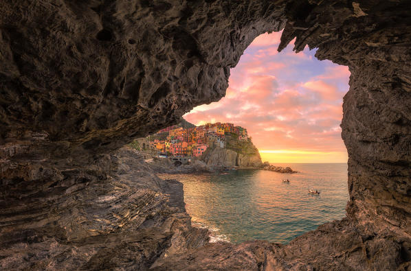 Transit of fishermen at the village of Manarola from a sea cave. Cinque Terre, Liguria, Italy, Europe.