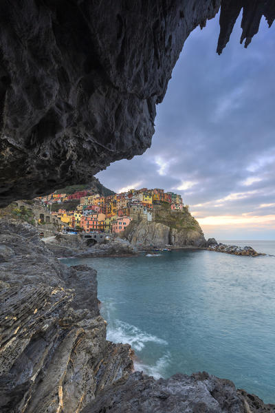 Sunrise on the village of Manarola from a sea cave. Cinque Terre, Liguria, Italy, Europe.