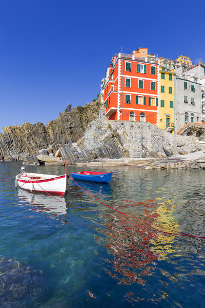 Colourful houses of Riomaggiore is reflected in the water. Cinque Terre, Liguria, Italy, Europe.