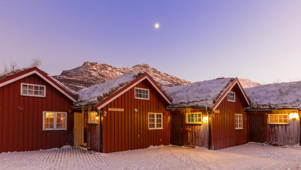 Traditional fishing houses used as accommodation for tourists during twilight. Lokvoll, Manndalen, Kafjord, Lyngen Alps, Troms, Norway, Lapland, Europe.
