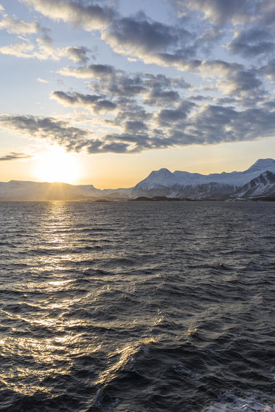 Sun setting while sailing by ferry in the fjord. Lyngenfjord, Lyngen Alps, Troms, Norway, Lapland, Europe.