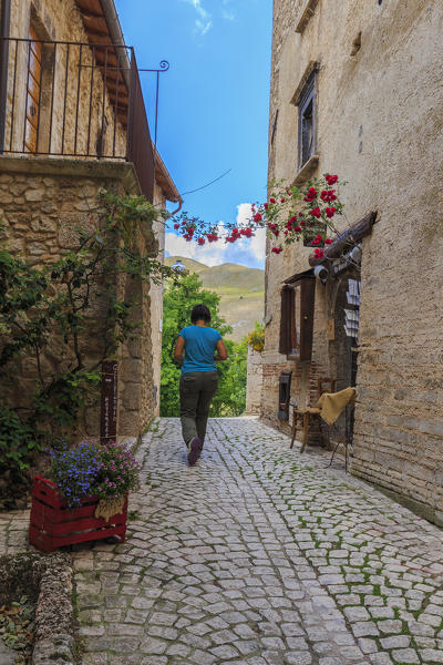 A person runs a street in the historic center Santo Stefano di Sessanio, Abruzzo, Italy.