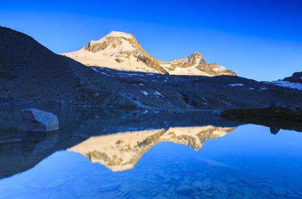Ciarforon and Bec de Montchair are reflected in Moncorvè lake. Vittorio Emanuele II Hut, Valsavarance, Gran Paradiso National Park, Aosta Valley, Italy, Europe