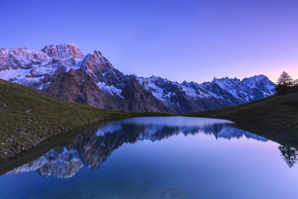 Mont Blanc mountain range is reflected in Lac Checrouit during dusk. Checrouit Lake, Veny Valley, Courmayeur, Aosta Valley, Italy, Europe