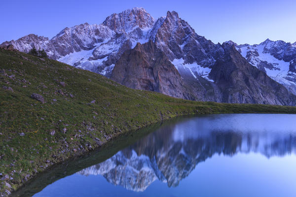 Mont Blanc mountain range is reflected in Lac Checrouit during dusk. Checrouit Lake, Veny Valley, Courmayeur, Aosta Valley, Italy, Europe