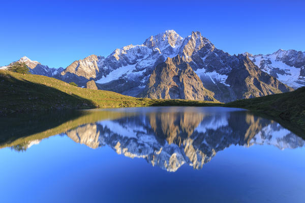 The sunlit Mont Blanc is reflected in Lac Checrouit. Checrouit Lake, Veny Valley, Courmayeur, Aosta Valley, Italy, Europe