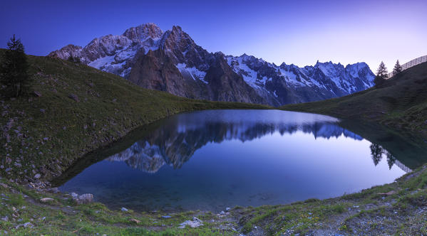 Mont Blanc mountain range is reflected in Lac Checrouit during dusk. Checrouit Lake, Veny Valley, Courmayeur, Aosta Valley, Italy, Europe