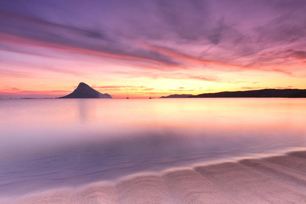 Amazing sunrise on the beach of Porto Taverna with the Tavolara Island in the background. Loiri Porto San Paolo, Olbia Tempio province, Sardinia, Italy, Europe.