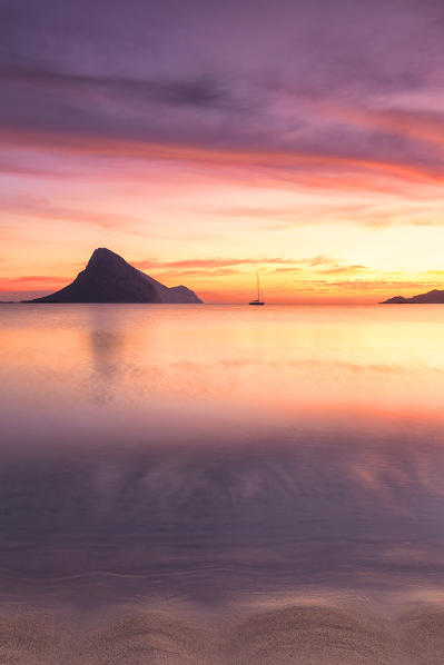 Amazing sunrise on the beach of Porto Taverna with the Tavolara Island in the background. Loiri Porto San Paolo, Olbia Tempio province, Sardinia, Italy, Europe.