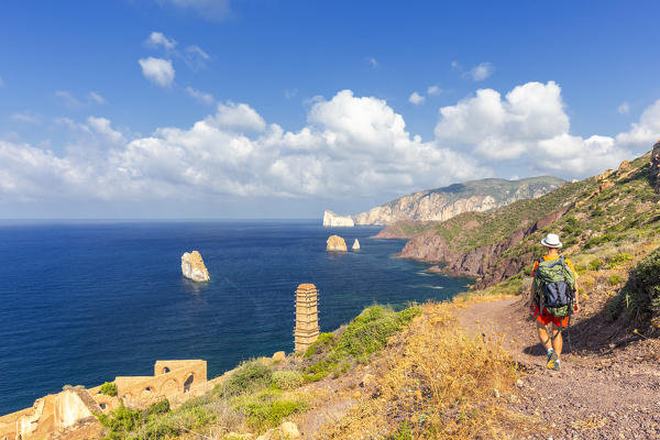 A tourist walks on a path for Laveria Lamarmora, Nebida, Iglesias, Sud Sardegna province, Sardinia, Italy, Europe. (MR)