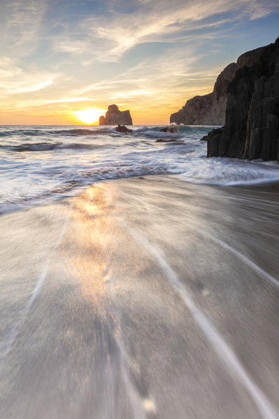 The sunset is reflected on the Beach of Masua, Iglesias, Sud Sardegna province, Sardinia, Italy, Europe.