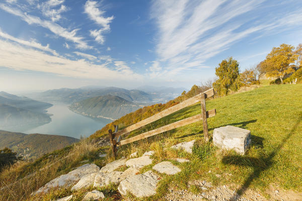 Autumn trees frame Lugano lake (Lugano district, Canton of Ticino, switzerland), view from the Sighignola (Lanzo d'Intelvi, Como province, Lombardy, Italy), Europe