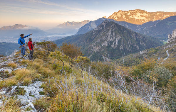 Two friends look a sunrise on Lecco mountains from Morterone, Lecco province, Lombardy, Italy, Europe (MR)