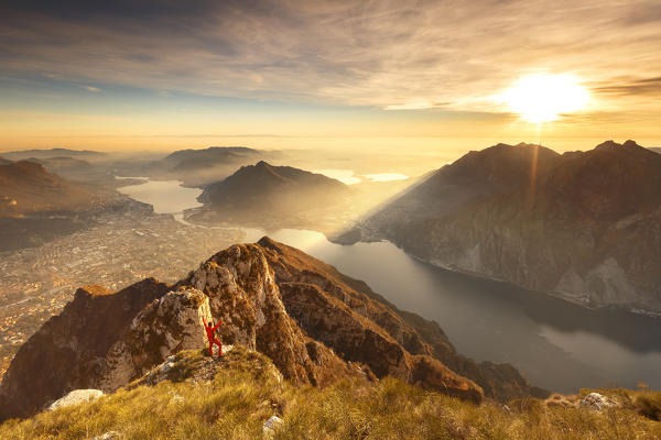 Hiker triumph illuminated by the light of the sunset on the top of Coltignone mount, Lecco province, Lombardy, Italy, Europe (MR)