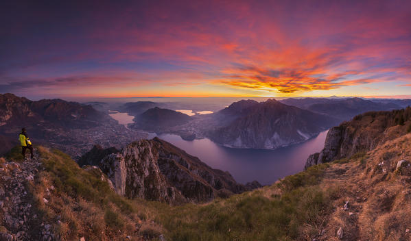 Hiker see a sunset on Lecco and lake Como from the top of Coltignone mount, Lecco province, Lombardy, Italy, Europe (MR)