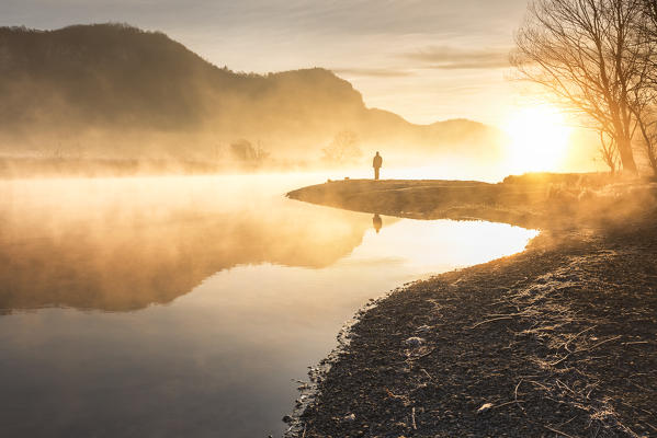 Man admire a foggy sunrise on Adda river, Airuno, Brianza, Lecco province, Lombardy, Italy, Europe (MR)